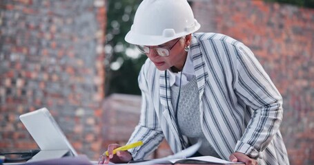 Poster - Architect, woman and writing with planning at construction site for design with application on tablet. Mature person, documents and touchscreen with notes, reading and outdoor for urban development