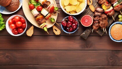 Canvas Print - summer bbq food top border hamburgers meat skewers potatoes fruit and snacks overhead view on a dark wood banner background copy space