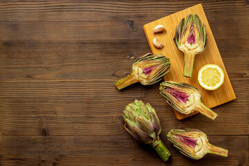 Wall Mural - Green artichokes heads with ingredients garlic and lemon. Cooking background