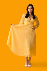 Poster - Beautiful young woman in stylish yellow dress on color background