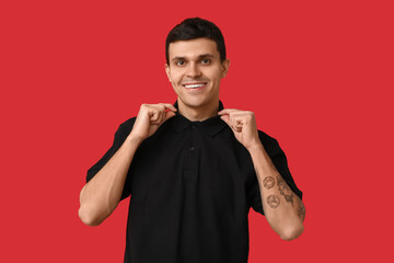 Sticker - Handsome young man in stylish black t-shirt on red background