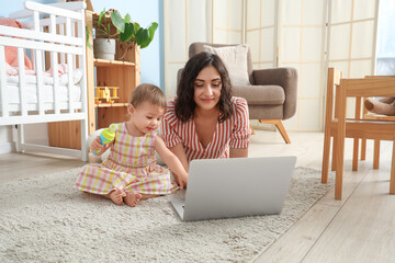 Sticker - Cute little baby with nibbler and mother using laptop in bedroom