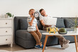 © Pixel-Shot - Naughty little boy shouting into megaphone near his working father at home