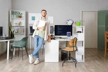 Canvas Print - Young bearded programmer with laptop in office