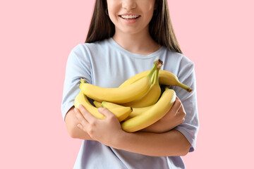 Wall Mural - Young woman with bananas on pink background, closeup