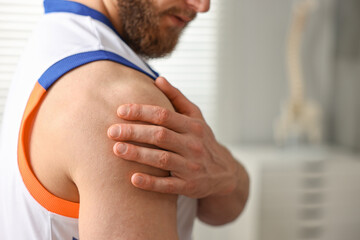 Canvas Print - Sportsman with injured shoulder in hospital, closeup