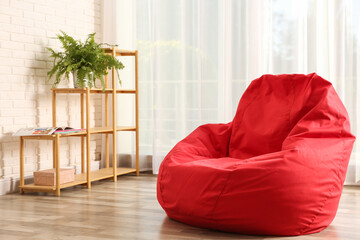 Wall Mural - Red bean bag chair on floor in room. Space for text