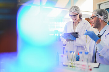 Wall Mural - scientists perform experiments and record data. people arranges equipment with test tubes and chemicals for producing medicine and biochemistry. man hold tubes of chemical liquids and plant samples.