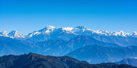 Wall Mural - A breathtaking view of snow-capped mountains against a clear blue sky on a crisp winter day