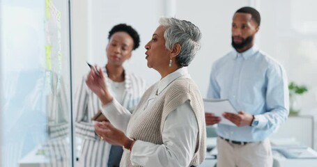 Wall Mural - Business woman, writing and board with team for training, presentation and notes at meeting in office. Mature leader, glass and group with strategy, planning and brainstorming at insurance company