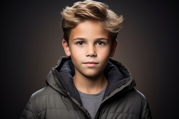 Poster - Portrait of a boy in a black down jacket. Studio shot.