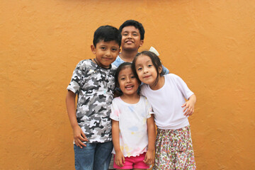 Two happy and excited dark-skinned Latino boys and 2 girls celebrate Children's Day by playing and laughing