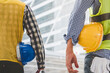 © aFotostock - Helmet construction Engineer team. Men hands holding hardhat yellow work helmet in Civil Construction Engineering. Close up engineer man hold safety yellow worker helmet hard hat at Construction Site