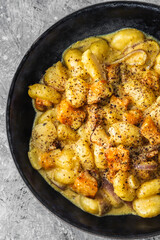 Wall Mural - turmeric gnocchi with pumpkin and onion in creamy sauce, healthy plant-based food