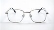 © Curie - A minimalist arrangement featuring a solitary pair of sleek, silver-framed glasses positioned centrally on a pristine white background.
