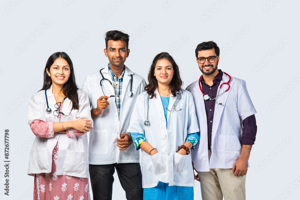 Doctors In Uniform Group portrait of four indian asian young doctors in uniform standing ...
