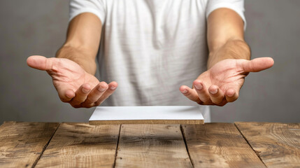 Poster - A man is holding a white piece of paper in his hands. The paper is on a wooden table. Concept of curiosity and wonder