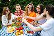 © maxbelchenko - Group of friends having backyard dinner party together. Young people enjoying leisure time together outside toasting with beer and barbecue. Vacation, picnic, weekend, nature.