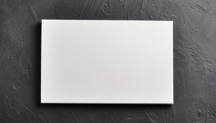 Wall Mural - Blank rectangular white poster on dark gray surface, mock-up for design presentations and portfolios