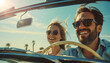 © Chlorophylle - Couple amoureux et heureux dans une voiture décapotable vintage faisant un voyage en vacances avec les cheveux aux vents