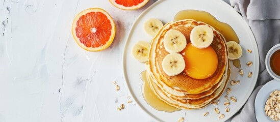 Aufkleber - Home-made pancakes piled with eggs, oats, bananas, maple syrup, and grapefruit on a white surface, with room for text, ideal for kids' meals. with copy space image. Place for adding text or design