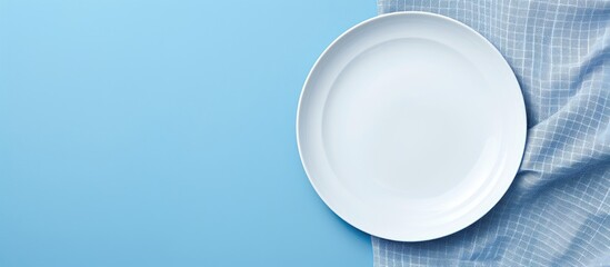 Poster - A picture showing a clean white plate and a soft cloth napkin set against a blue background provides a food-themed copy space image, ideal for menus and recipe books, featuring a table setting in a