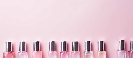 Poster - A pastel pink background with an array of vibrant nail polish bottles displayed in a flat lay arrangement with available copy space image.