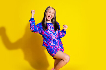 Photo of ecstatic girl with dyed hairstyle dressed print shirt clenching fists yell win gambling isolated on yellow color background