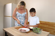 © Vasyl - Mother and son cooking pizza at home.