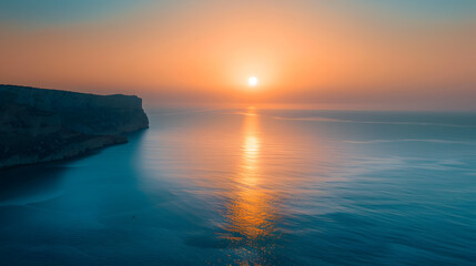 Wall Mural - The ocean is calm and the sun is setting, creating a beautiful