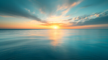 Wall Mural - The sun is setting over the ocean, casting a warm glow on the water