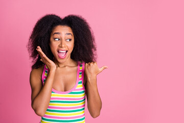 Sticker - Photo of overjoyed woman with perming coiffure dressed knit tank indicating look at logo empty space isolated on pink color background