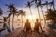 © Song_about_summer - holidays, couple relaxing near swimming pool in luxury hotel resort at sunset on tropical island, honeymoon vacation travel