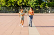 © Xavier Lorenzo - Two young female friends jogging together in summer. Two female runners enjoying healthy training outdoor workout routine. Healthy lifestyle concept.