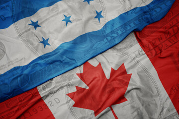 Wall Mural - waving colorful flag of honduras and national flag of canada on the dollar money background. finance concept.
