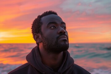 Wall Mural - Portrait of a tender afro-american man in his 30s wearing a thermal fleece pullover in vibrant beach sunset background