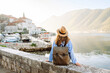 © maxbelchenko - Back view of Tourist woman on the observation deck admiring view of colorful the view of the city and gulf. Travel, vacation, active lifestyle.