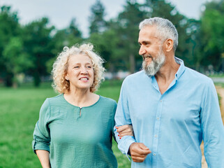 Wall Mural - woman man mature couple happy together active bonding park outdoor middle aged talking leisure park fun smiling love old middle mid aged nature wife walking