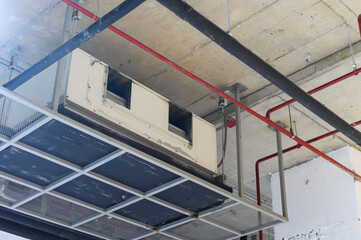 Wall Mural - Ceiling mounted cassette type air conditioner in factory hall.