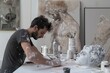 © Inigo - Artist working on a white marble sculpture in his studio. Contemporary art concept.