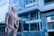 © GAJENDRRA BHATI  - senior indian business person standing in front of modern, corporate glass office. success, growth and workplace concept.