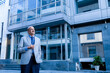 © GAJENDRRA BHATI  - senior indian business person standing in front of modern, corporate glass office. success, growth and workplace concept.