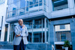 © GAJENDRRA BHATI  - senior indian business person standing in front of modern, corporate glass office. success, growth and workplace concept.