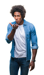 Canvas Print - Afro american man over isolated background looking at the camera blowing a kiss with hand on air being lovely and sexy. Love expression.