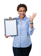 Wall Mural - Young african american businesss woman holding clipboard over isolated background very happy and excited, winner expression celebrating victory screaming with big smile and raised hands