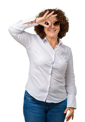 Poster - Beautiful middle ager senior business woman wearing sunglasses over isolated background doing ok gesture with hand smiling, eye looking through fingers with happy face.