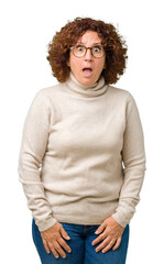 Poster - Beautiful middle ager senior woman wearing turtleneck sweater and glasses over isolated background afraid and shocked with surprise expression, fear and excited face.