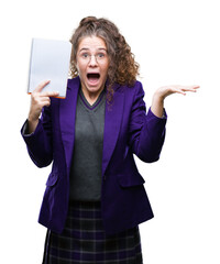 Wall Mural - Young brunette student girl wearing school uniform holding a notebook over isolated background very happy and excited, winner expression celebrating victory screaming with big smile and raised hands