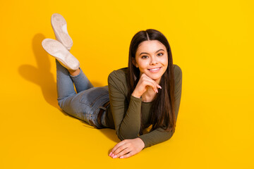 Poster - Full length photo of lovely teen lady lying floor relaxed dressed stylish khaki garment isolated on yellow color background