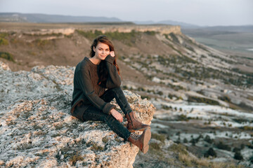 Wall Mural - Solitude in the desert woman contemplating mountains from rock perch